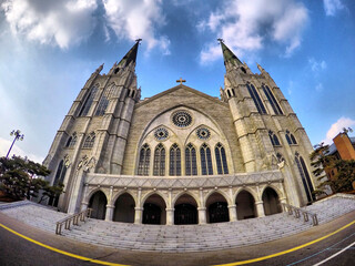 Neo-Gothic Cathedral with Twin Spires under Blue Sky – Wide Angle View
