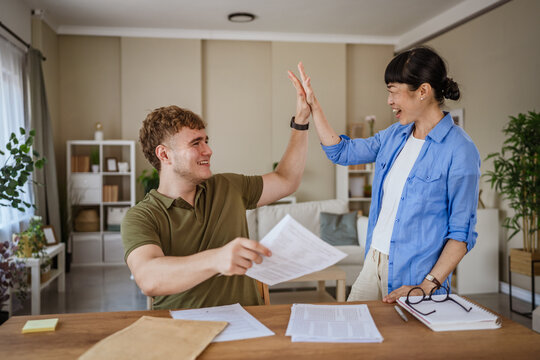 Happy student and teacher giving high five after successful exam correction
