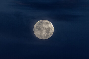 Lunar sphere: The moon glows in the dark night sky, its surface features captured in exquisite detail.
