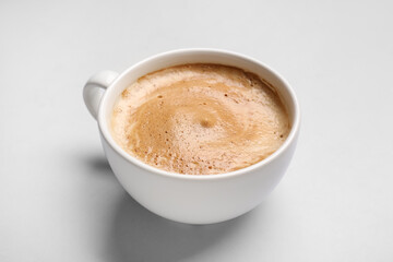 Cup of hot espresso on grey background