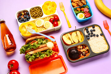 Lunchboxes with different tasty food on lilac background