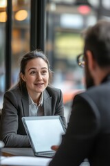 Fototapeta premium A woman in business attire smiling at a man during an informal meeting at a cafe.