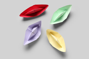 Colorful origami boats on grey background