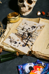 Witch's magic attributes with book and tarot cards on dark table