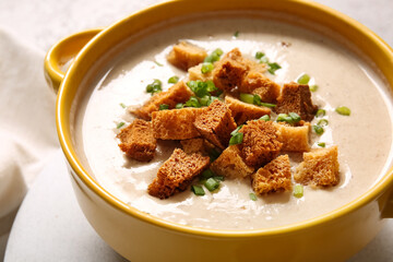 Pot of tasty cream soup with croutons on table
