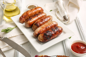Plate of tasty grilled sausages on white wooden background