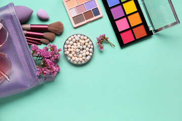 Cosmetic bag with makeup products and beautiful gypsophila flowers on turquoise background