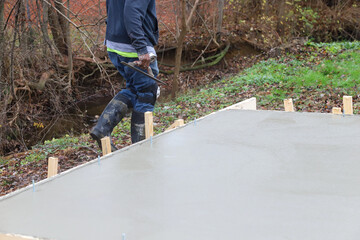 Crew of concrete workers pouring and leveling a shed pad © Robin
