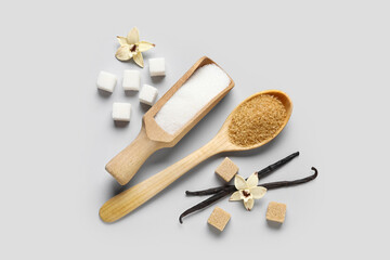 Wooden scoop and spoon with aromatic vanilla sugar on grey background