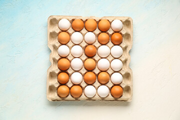 Chicken eggs in cardboard box on blue grunge background