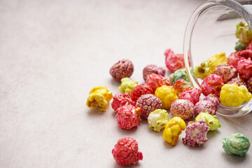 Glass with sweet colorful popcorn on white background