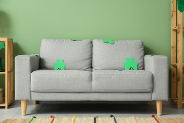 Grey sofa with clovers in interior of festive living room. St. Patrick's Day celebration