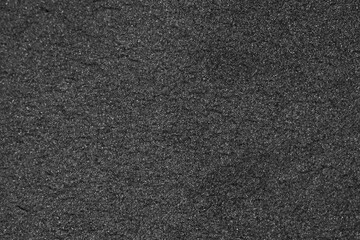 Black Sand Close-Up Showcasing Fine Texture and Shimmering Particles Under Natural Light on a Bright Day