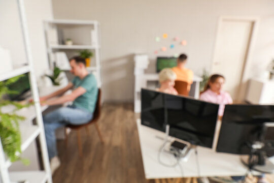 Team of programmers working in office, blurred view
