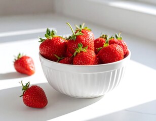 Fresh strawberries in a white bowl on a light surface