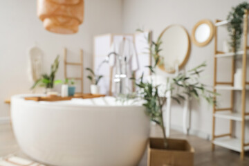 Blurred view of bathroom with mirrors, bathtub and folding screen