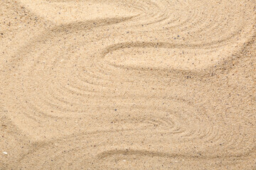 Texture of beach sand with lines as background, closeup