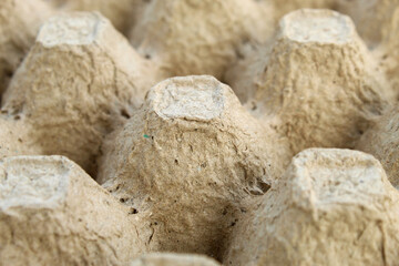 Empty egg carton texture made from textured recycled material, neutral gray in color. This natural background is suitable for eco-friendly designs, recycled themes, or organic product presentations.