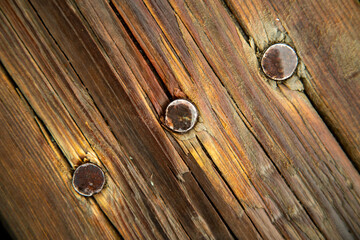 Three large nails in old weathered boards