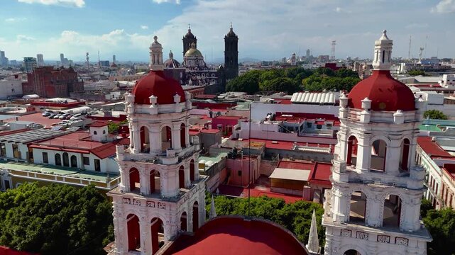 Drone flying between bell towers of Expiatorio del Esp&iacute;ritu Santo church in Puebla with cathedral and colonial buildings in background
