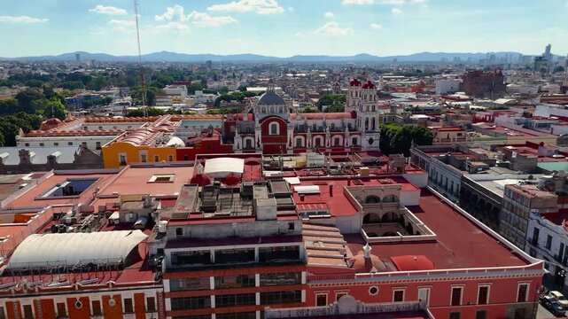 Drone orbit around Expiatorio del Esp&iacute;ritu Santo neo-gothic church in Puebla, showing dome and bell towers with cathedral and city buildings