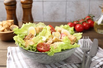Delicious salad with croutons and ingredients on wooden table, closeup