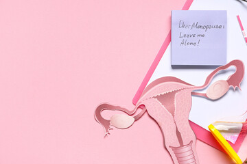 Paper with text DEAR MENOPAUSE LEAVE ME ALONE, clipboard and paper uterus on pink background
