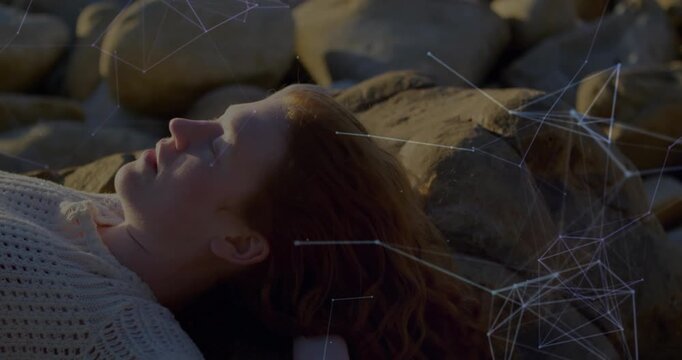 Woman reclining on stones playing audio activating expanding digital mesh overlay for tech demo