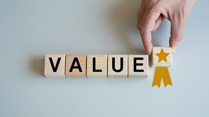 Hand places the final wooden block spelling value with a golden star and ribbon award symbolizing excellence and high worth