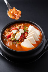 Korean food (Kimchi Jjigae), Kimchi soup with tofu, pork, scallion and chili in Korean stone bowl ready to eating