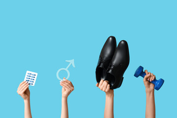 Female hands with pills, symbol of man, shoes and dumbbell on blue background. Prostate Cancer...