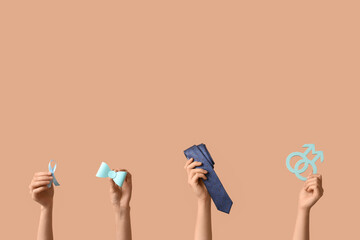 Female hands with blue ribbon, symbols of man and accessories on beige background. Prostate Cancer Awareness Month