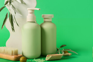 Composition with bottles of natural cosmetic products, massage brush, plaster decor and green olives on color background