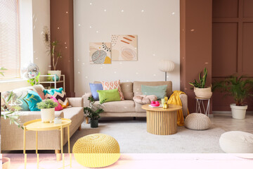Interior of festive living room with grey sofas, poufs and disco ball