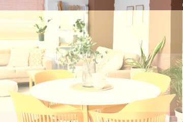 Vase with eucalyptus branches and cups on table in living room