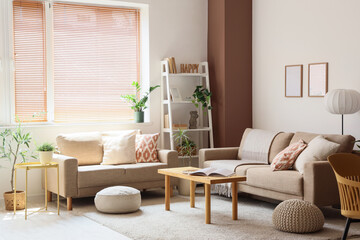 Interior of stylish living room with grey sofas, houseplants and coffee table