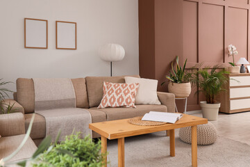 Interior of stylish living room with grey sofas, houseplants and coffee table