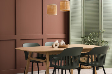 Interior of stylish dining room with wooden table, chairs and lamps