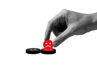Close up of a person s hand placing a red sad face emoji on a dark surface isolated on transparent background