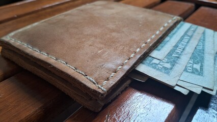 Elegant leather wallet with dollar bills inside