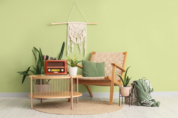 Interior of stylish living room with armchair and retro radio on coffee table