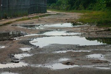 broken asphalt road. the asphalt road with potholes and waterlogged after the rain	
