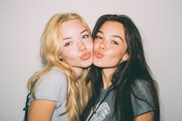 Teenage girls of different backgrounds enjoying time together posing joyfully against a white backdrop