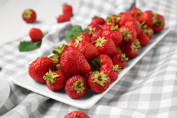 Plate with sweet ripe strawberries on white background, closeup