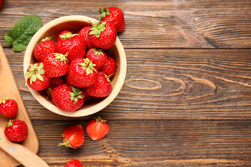 Bowl with sweet ripe strawberries and mint leaf on wooden background © Pixel-Shot