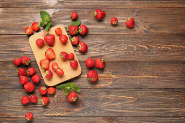 Cutting board with sweet ripe strawberries and mint leaves on wooden background