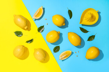 Fresh ripe lemons with leaves and juicer on colorful background