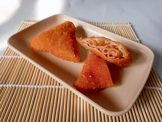 Triangle Fried Risoles or Risol mayo is a typical Indonesian traditional street food isolated on white background.