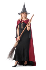 Happy mature woman dressed as witch with broom isolated on white background. Halloween celebration