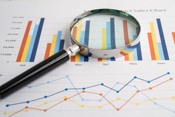 Magnifying glass on spreadsheet and graph paper. Financial development, Banking Account, Statistic, Investment Analytic research data economy, Business.